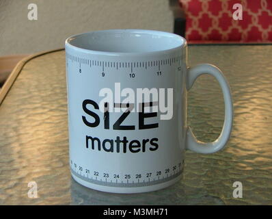 large coffee cup with size matters saying and ruler markings top and bottom Stock Photo
