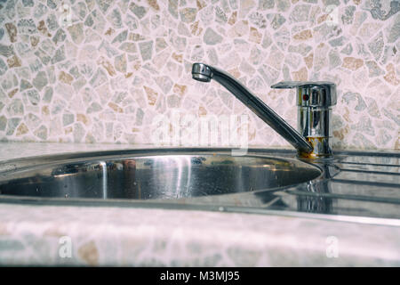 Chrome Faucet and Sink in the Kitchen Stock Photo