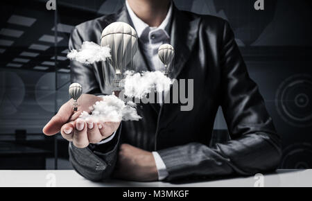 Woman presenting flying balloon in hand. Stock Photo