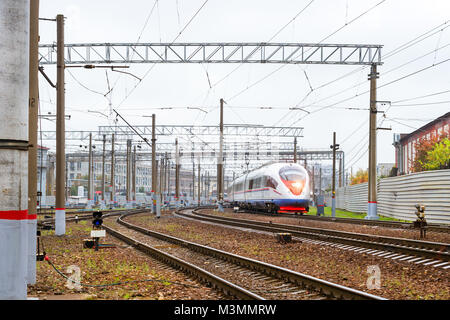 Modern hybrid electric locomotive pulling a high-speed train on rails. Technical railway depot. Transport route Saint-Petersburg - Moscow, Russia Stock Photo