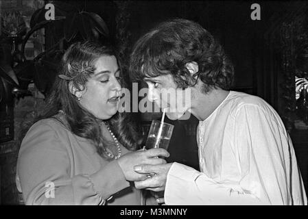 Donovan share a drink with party hostess Mama Cass Elliot at 'The Factory' in Hollywood. September 1969. 'This was taken in Los Angeles in 1969 for the launch of my album Barabajagal. I’d not long come back from India, seeing the Maharishi with the Beatles, so I was wearing my whites – Indian shirt, pantaloons and sandals'. Donovan Leitch Stock Photo