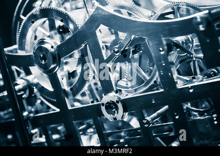 Mechanical clock close-up fragment with shiny gears, blue toned photo Stock Photo