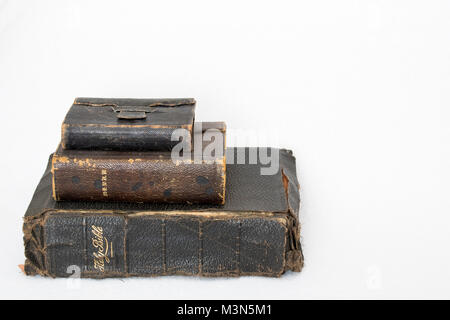 Stack of Three Antique Worn Leather Bibles on White Background Stock Photo