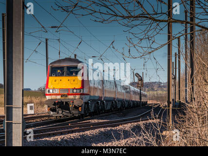 A southbound Virgin train on the East Coast main line near Alnmouth, Northumberland, North East England, on a fine winter day with a clear blue sky Stock Photo