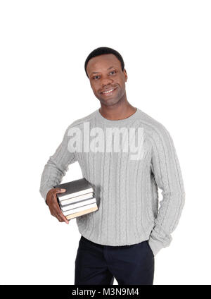 A handsome smiling young African American man standing and holding his book under his arms, isolated for white background Stock Photo