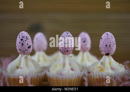 delicious home baked Easter time chocolate cupcakes decorated with pink Easter eggs Stock Photo