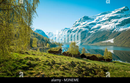 Beautiful norwegian landscape with old farm, lake and mountains Stock Photo
