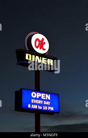 The fluorescent sign of a roadside, Diner from the OK Diner chain of restaurants with opening times at night. Stock Photo