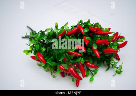 Sweet red pepper kapi, three peppers on white wooden table Stock Photo