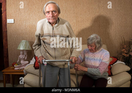 Elderly man learning to walk again after illness Stock Photo