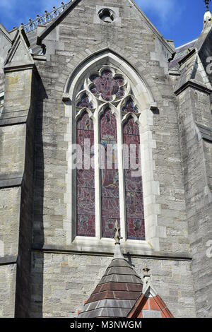 Large arched stained glass window of stone chapel of St Patrickâ€™s College in Maynooth University. Stock Photo