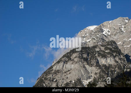 Small traditional Austrian cabin perched on top of a massive cliff in the Alps Stock Photo