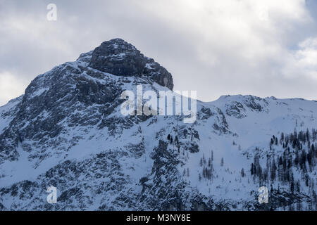Lonely alpine peak in the late evening light on a cold winter day in the Alps Stock Photo