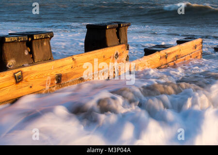 Richly coloured pine groyne on winter beach with stormy sea on sunny day in bexhill-on-sea England Stock Photo