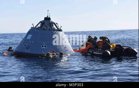 180121-N-ZZ513-121  PACIFIC OCEAN (Jan. 21, 2018) Navy divers from Explosive Ordnance Disposal Mobile Unit (EODMU) 3 attach an inflatable ring to NASA’s Orion test vehicle to the San Antonio-class amphibious transport dock ship USS Anchorage (LPD 23), Jan. 21, 2018. Anchorage is underway to support NASA’s Orion spacecraft Underway Recovery Test 6 (URT-6). (U.S. Navy photo by Mass Communication Specialist 3rd Class Natalie M. Byers/Released) U.S. Navy divers support NASA's Orion spacecraft underway recovery test in the Pacific Ocean by #PACOM Stock Photo