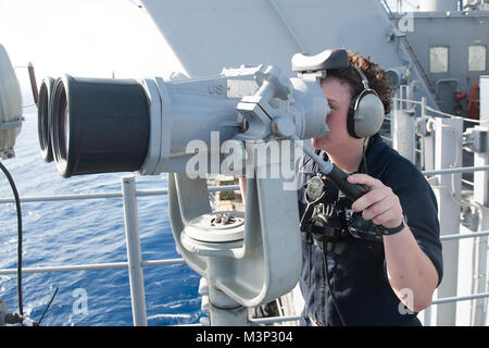 180121-N-HT134-009 PACIFIC OCEAN (Jan. 21, 2018) Seaman Christina Cook a native of Cornwallville, N.Y., assigned to the amphibious assault ship USS America (LHA 6), keeps a sharp lookout using the ship’s binoculars on forward lookout. America, part of the America Amphibious Ready Group, with embarked 15th Marine Expeditionary Unit, is returning from a 7-month deployment to the U.S. 3rd, 5th and 7th fleet areas of operations. (U.S. Navy photo by Mass Communication Specialist Seaman Daniel Pastor/Released) U.S. Sailor stands the forward lookout as USS America returns from 7-month deployment by # Stock Photo