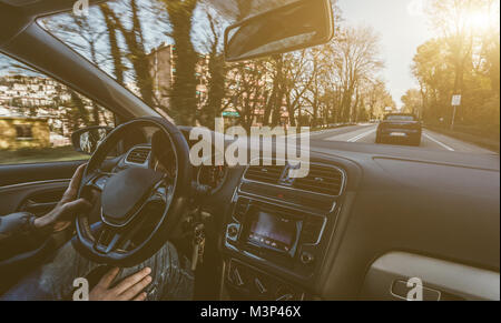Young man driving a car with one hand. Concentrating and safe driving on the road concept. Stock Photo