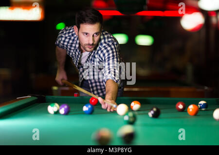 Young attractive man playing pool in bar Stock Photo