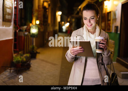 Attractive young woman using tablet and drinking coffee Stock Photo