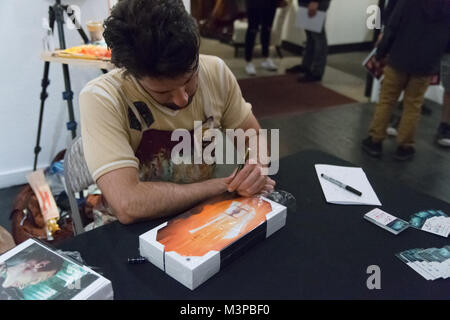 Las Vegas, USA. 09th Feb, 2018. Artist Christopher Clark sings art for fans at his Las Vegas Art Show on February 9th 2018 at the Arts Factory in the Art District of downtown Las Vegas, NV. Credit: The Photo Access/Alamy Live News Stock Photo