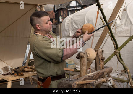 York, UK, 12th February 2018. Person dressed as a Viking at the annual Jorvik Viking Festival held in the city centre of York. This man is a skilled wood-turner & is holding & examining a wooden bowl he has just finished crafting, using a simple lathe & handmade tools. He is taking part in the realistic re-enactment of life at a Viking market. North Yorkshire, England, UK.  Credit: Ian Lamond/17�Թ����� Live News Stock Photo
