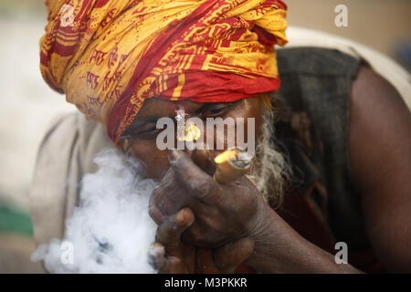 Kathmandu, Nepal. 12th Feb, 2018. A Sadhu whom is considered holy smokes marijuana from a chillum on the eve of the Maha Shivaratri festival inside Pashupatinath Temple in Kathmandu, Nepal. Thousands of sadhus from India and Nepal come to celebrate the festival of Maha Shivaratri by smoking marijuana, smearing their bodies with ash and offering prayers devoted to the Hindu Deity Lord Shiva. Credit: Skanda Gautam/ZUMA Wire/Alamy Live News Stock Photo