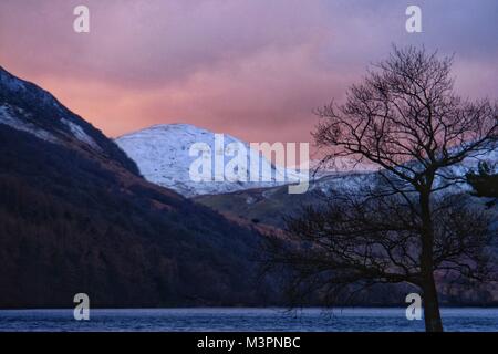 Buttermere, Cumbria, UK  12th  February. 2018.  After a cold day in the Lake District heavy sky’s and a setting sun combine to produce a stunning sunset on Buttermere. Credit: Tom Corban/Alamy Live News Stock Photo