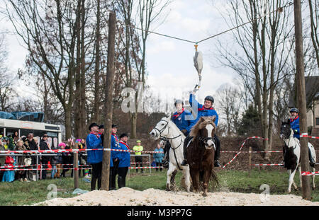 Bochum, Germany, 12 February 2018.  Bochum, Germany. 12th Feb, 2018. The day's winner of the traditional geese riding of the Geese Rider Club Sevinghausen, Joerg Wendorf (2-R), reaches for the wooden goose in Bochum, Germany, 12 February 2018. The custom of geese riding is to be gotten to the Bochum region from Spanish soldiers in the 16th century. Thereby, a dead geese was hung up at a height of several metres, with her head hanging downwards.  Credit: Bernd Thissen/dpa/Alamy Live News Stock Photo