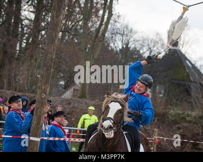 Bochum, Germany, 12 February 2018.  Bochum, Germany. 12th Feb, 2018. The day's winner of the traditional geese riding of the Geese Rider Club Sevinghausen, Joerg Wendorf, reaches for the wooden goose in Bochum, Germany, 12 February 2018. The custom of geese riding is to be gotten to the Bochum region from Spanish soldiers in the 16th century. Thereby, a dead geese was hung up at a height of several metres, with her head hanging downwards.  The custom annually takes place on Shrove Monday. Credit: Bernd Thissen/dpa/Alamy Live News Stock Photo