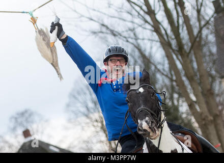 Bochum, Germany, 12 February 2018.  The day's winner of the traditional geese riding of the Geese Rider Club Sevinghausen, Joerg Wendorf, celebrates with the head of the wooden goose in his hands in Bochum, Germany, 12 February 2018. The custom of geese riding is to be gotten to the Bochum region from Spanish soldiers in the 16th century. Thereby, a dead geese was hung up at a height of several metres, with her head hanging downwards. Credit: Bernd Thissen/dpa/Alamy Live News Stock Photo