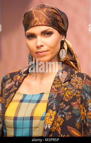 London, UK. 12th Feb, 2018. Pure London A/W 2018/19, Olympia, London, UK. Model wears clothes by Villagallo and Bright & Beautiful. Hat by Fonem. Earrings by Kiwi   Pomelo. Credit: Antony Nettle/Alamy Live News Stock Photo