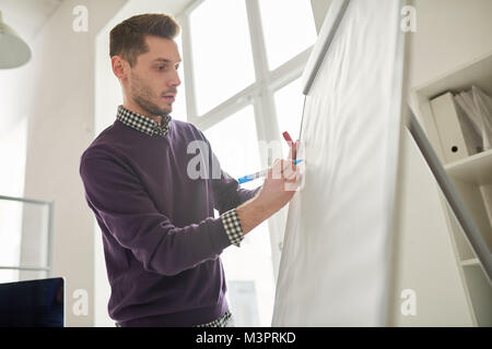 Young Man Writing on Whiteboard Stock Photo