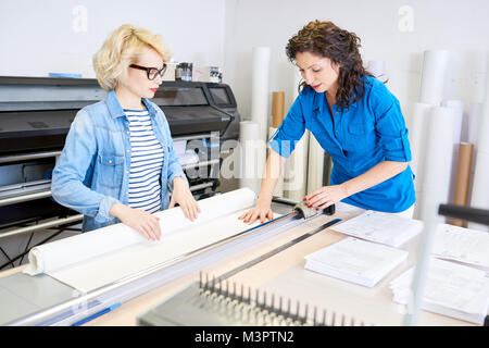 Women Cutting Paper in Printing Shop Stock Photo