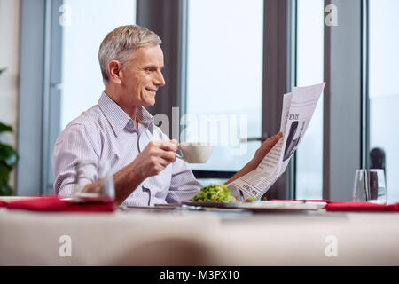 Joyful mature man relishing coffee Stock Photo