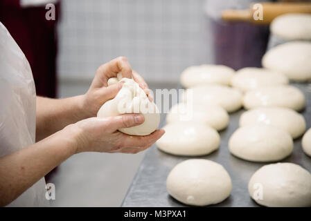Female hands preparing dough for pizza closeup, restaurant Stock Photo