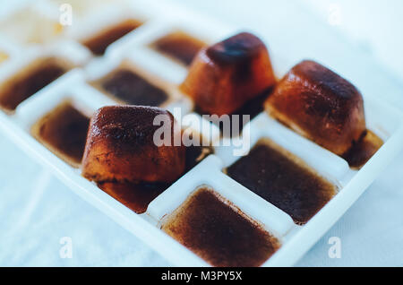 Ice cubes made with coffee in blue ice cube tray to prepare refreshing  coffee drinks like iced coffee. White background, view from above, isolated  Stock Photo - Alamy