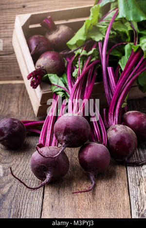 Organic  farm. Bunch of whole beetroots with green leaves, vegetables on rustic wooden background Stock Photo