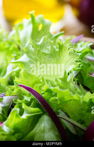 Fresh leaf vegetable salad with lettuce and red onion in ceramic bowl on rustic wooden table Stock Photo