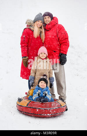 Photo of happy parents with daughter and son on winter walk Stock Photo