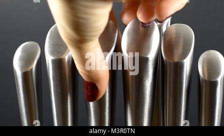 Hand Picking A Stainless Steel Knife From A Bamboo Stand Stock Photo