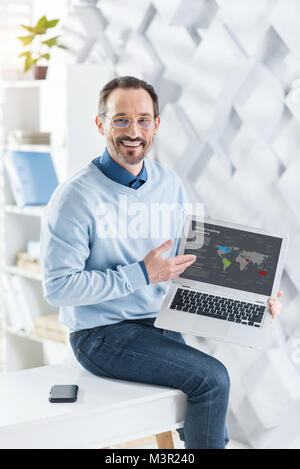 Happy businessman showing information on his laptop Stock Photo