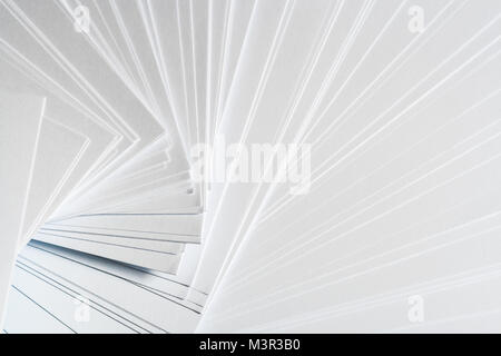 White geometric background from stack of clean sheets  paper, laid out randomly in a spiral. Stock Photo