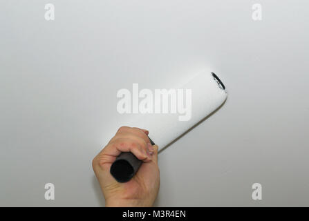 Paint the ceiling a woman's hand paints the ceiling Stock Photo