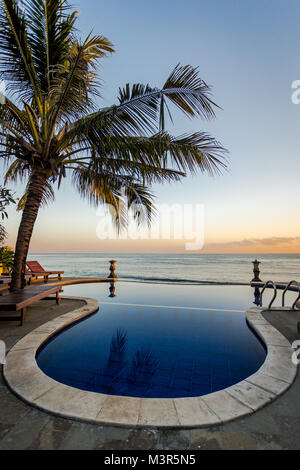 A Balinese infinity pool overlooking the Indian Ocean during a glorious sunset. Stock Photo