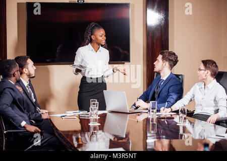 Businesswoman Leads Meeting Around Table Shot Stock Photo