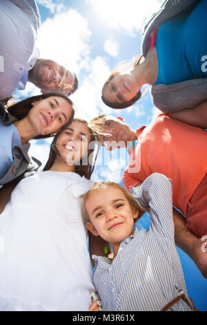 Group of happy smiling friends against blue sky. Low angle view Stock Photo