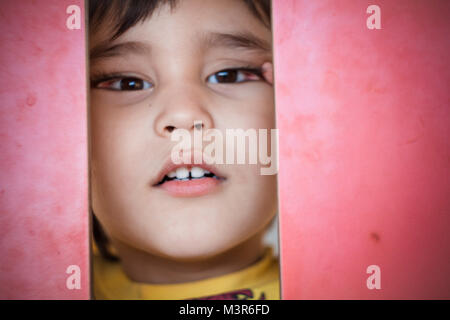 Brunette boy putting funny faces in an outdoor park Stock Photo