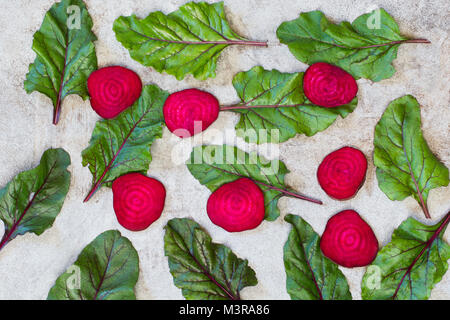 Raw beetroots sliced and mangold leaves on rustic board . View from above.  Vegetables background. Flat lay. Stock Photo