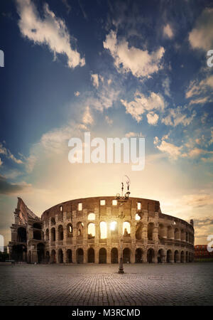 Ancient roman colosseum and sunny sunrise in Rome, Italy