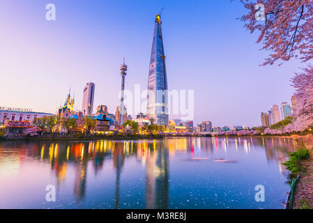 SEOUL, KOREA - APRIL 7, 2016: Lotte World Seokchon Lake park at night and cherry blossom of Spring in Seoul, South Korea on April 7, 2016 Stock Photo